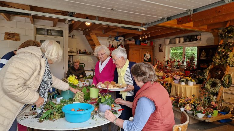 Kransvriendinnen maken bloemdecoraties voor bazaar