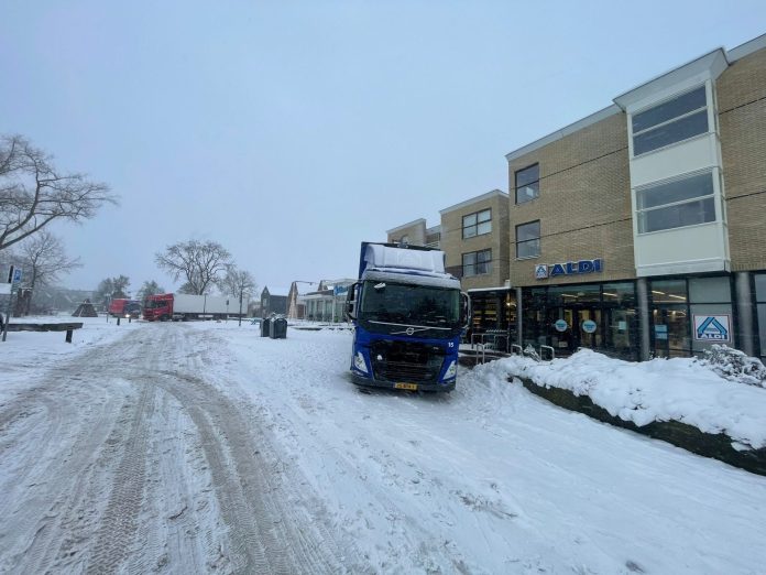 Vrachtwagen in de sneeuw op Sinnebuorren in Joure