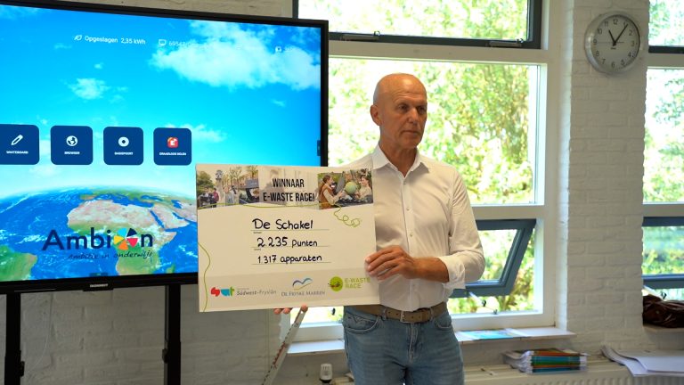 Wethouder Jan van Zanden toont het aantal behaalde punten en het aantal ingezamelde elektrische apparaten.